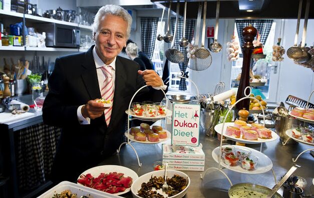 Pierre Dukan rodeado de pratos dietéticos